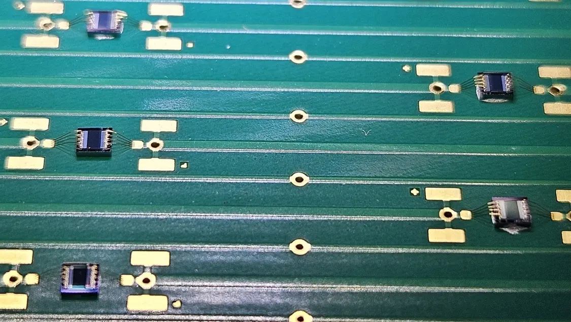 Close-up of wire bonded test capacitors on the PCB